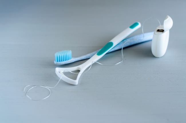 Koncepce zdraví ústní hygieny. Detailní dentální nástroje zubní kartáček a škrabka na jazyk.
